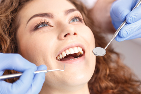 Dentist examining a patients teeth in the dentist