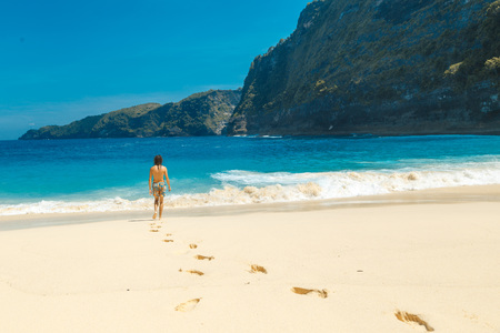 Male on hot summers day on beach going for a swim in oceanの写真素材