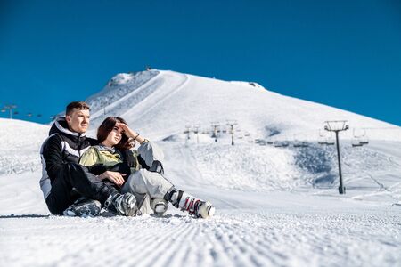Young happy couple in snowy mountains. Winter sport vacation