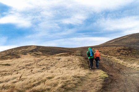 Fall. Couple Backpackers hiking on the path in mountains during autumn.の写真素材
