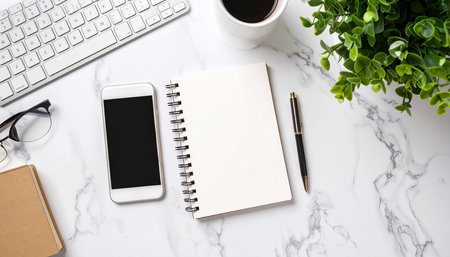 White office desk table with keyboard, smartphone, notebook and coffee cup. Top view with copy spaceの素材