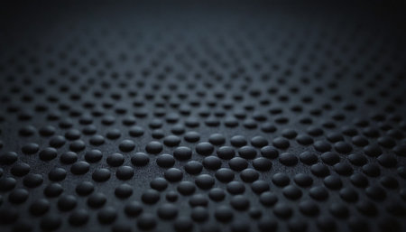 Close up of black perforated textured surface. Abstract background.の素材