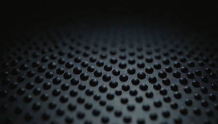 Black perforated metal background, close-up. Selective focus.の素材