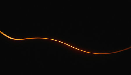 Orange light lines on a black background. Abstract background with copy space.の素材