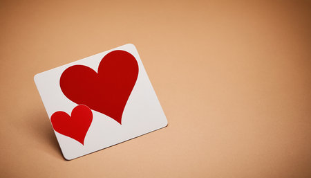 Two red hearts on a white card with copy space on brown backgroundの素材