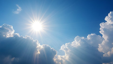 Blue sky background with white clouds and bright sun. Nature composition.の素材