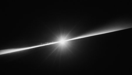 Black and white image of a ray of light against a dark backgroundの素材
