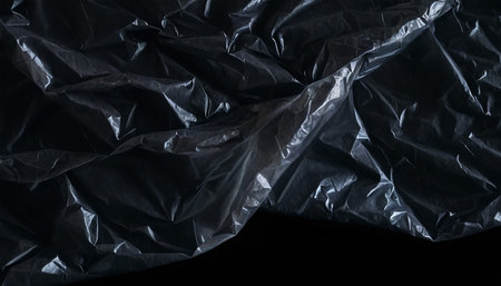 Black crumpled plastic bag texture. Abstract background and texture for design.の素材