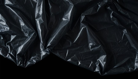 Black crumpled paper sheet isolated on black background with clipping pathの素材