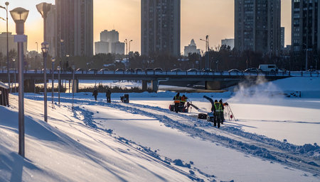 Workers clean the snow on the embankment.の素材