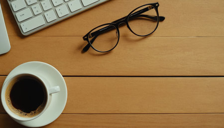 Office desk table with keyboard and coffee cup. Top view with copy spaceの素材