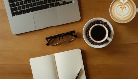 Coffee cup with notebook and laptop on the wooden table.の素材