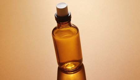 A bottle of essential oil on a beige background close-upの素材