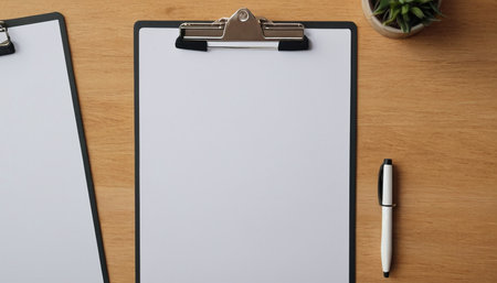 Clipboard with blank paper and pen on wooden desk, stock photoの素材