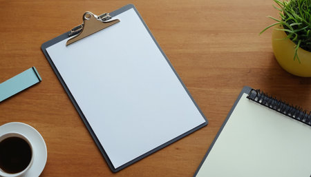 Blank clipboard and coffee cup on wooden table with copy space.の素材