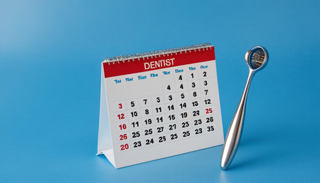 dental mirror and calendar on blue background. 3d rendering.の素材
