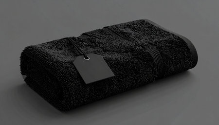 Black terry towel with label on grey background. 3d renderingの素材