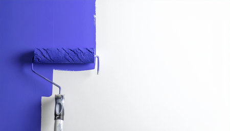 Roller painting the wall with blue paint on white background, copy spaceの素材