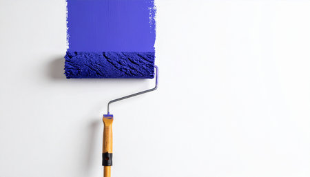 Paint roller with blue paint on a white background. Painting conceptの素材
