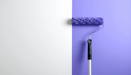 Roller with blue paint on purple and white background, copy spaceの素材
