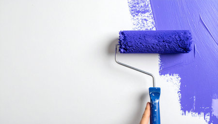 Painting the wall with blue paint roller, close-up.の素材