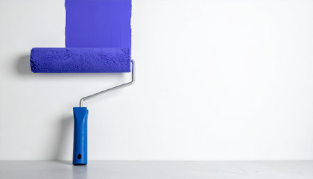 Painting the wall with blue paint roller, close-up.の素材