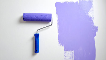 Paint roller with blue paint on a white background. Painting conceptの素材