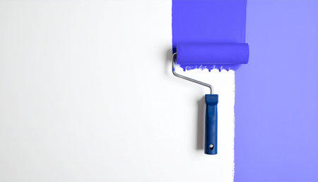 Roller with blue paint on a white background. Painting the wall with a roller.の素材