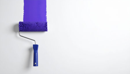 Paint roller with purple paint on white wall, copy space.の素材