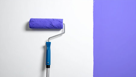Paint roller with blue paint on a white and purple background.の素材