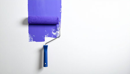 Roller with blue paint on a white background. Painting the wall.の素材