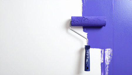 Paint roller on a white wall. Painting the wall with blue paint.の素材