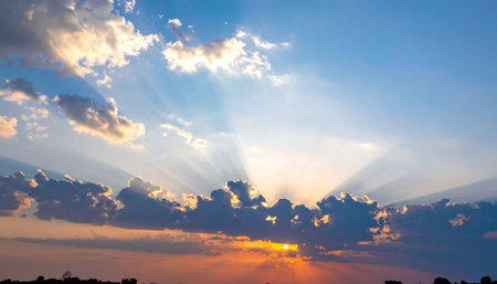 Sunset sky with clouds and sun rays. Beautiful nature background.の素材