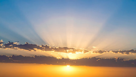 Beautiful sunset sky with clouds and sun rays. Nature background.の素材