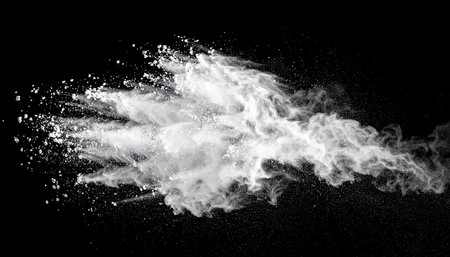 White powder explosion isolated on black background. Abstract white dust cloud texture.の素材