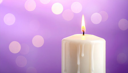 Burning candle on purple background, closeup. Festive decorationの素材