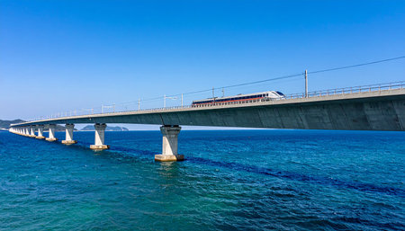 The bridge over the sea with a train on it and blue skyの素材