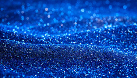Close-up of a deep blue glitter texture with soft bokeh highlights creating a shimmering and luminous effectの素材