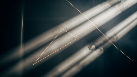 Abstract image of a geometric pattern on a dark background with rays of lightの素材