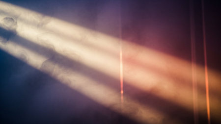 Colorful rays of light on a dark background with smoke and fogの素材