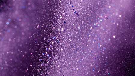 An abstract close-up of a dynamic explosion of purple glitter and particles suspended in motion against a dark background. Tiny shimmering specks and larger iridescent fragments are scattered, creating a sense of energy and movement. The is rich in texture and light, with a bokeh effect adding to its ethereal and magicalの素材