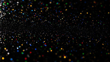 A dark, black background is filled with a multitude of small, scattered, colorful bokeh lights. These out-of-focus circles of light appear in various vibrant hues, including red, green, blue, yellow, and white, creating a festive and dynamic visual texture. The lights are randomly distributed, giving the impression of glitter or distant stars. The overall effect is abstract, luminous, and celebratory.の素材