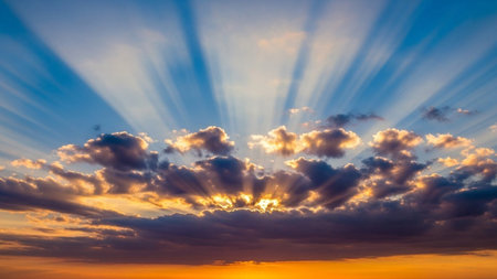 20251228 showing dramatic sunrise sky with golden sun rays bursting through dark clouds over a fiery orange horizon....の素材