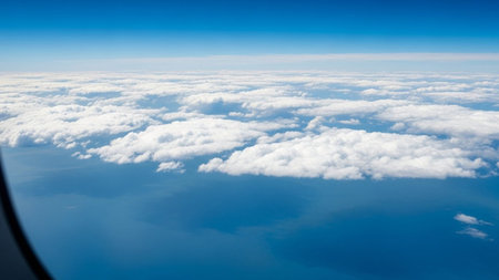 20251228 showing aerial view of fluffy white clouds over deep blue ocean and horizon from airplane window keywords:...の素材