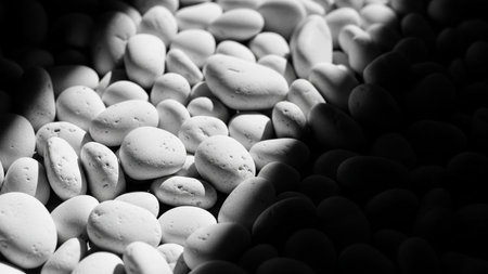 20251228 showing close up black and white texture of smooth white pebbles with dramatic light and shadow playful...の素材