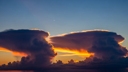 Textures showing dramatic sunset sky with large cumulonimbus clouds illuminated by fiery orange and yellow light...の素材