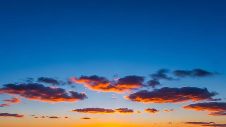 20251228 showing vibrant sunset sky with fiery orange clouds against a deep blue gradient horizon. resolution...の素材