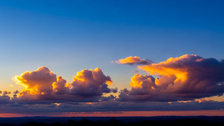 A dramatic sunset sky filled with vibrant orange and yellow clouds, set against a deep blue horizon.の素材