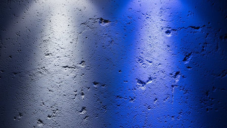 A rough concrete wall is dramatically lit by contrasting white and blue spotlights casting distinct shadows.の素材