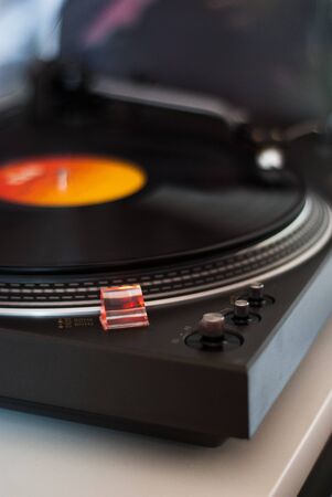 Close-up of a vintage metal turntable playing a vinyl record